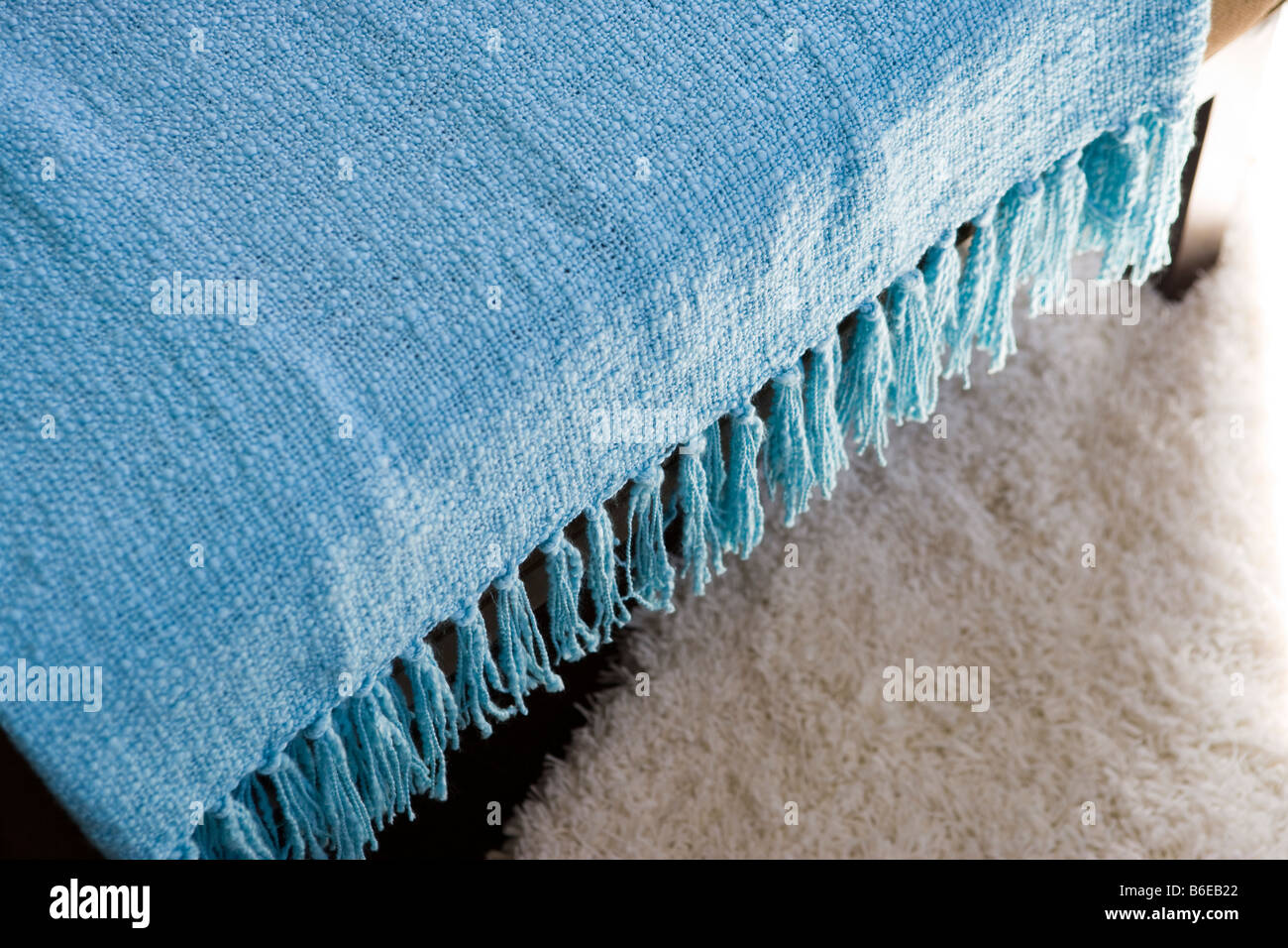 Blaue Decke mit Quasten hängen über Stuhl Stockfoto