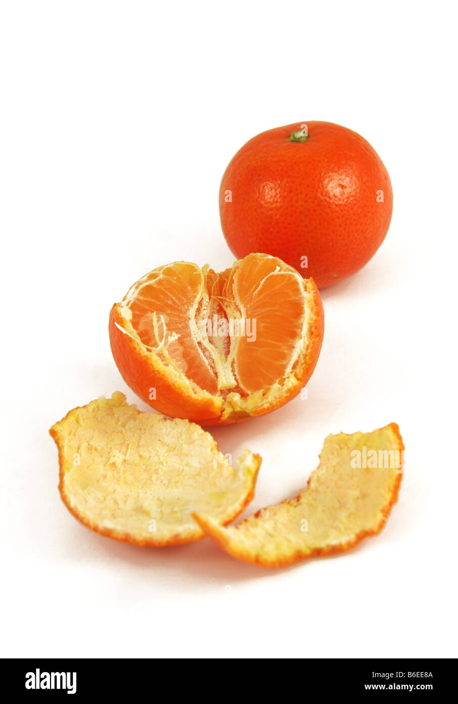 Eine halbe geschälte orange sitzt vor der ungeschälten ein. Stockfoto