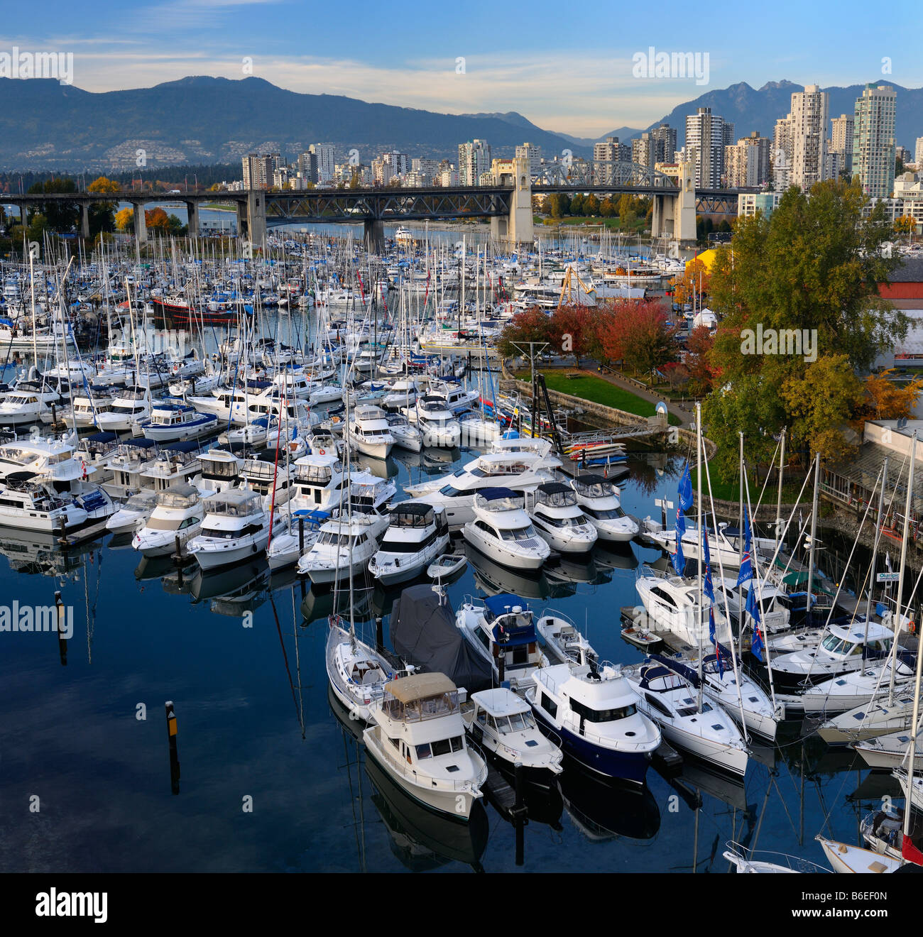 Boote auf Granville Island Boat Yard und Burrard Marina mit Brücke und Coastal Mountains Vancouver Kanada Stockfoto