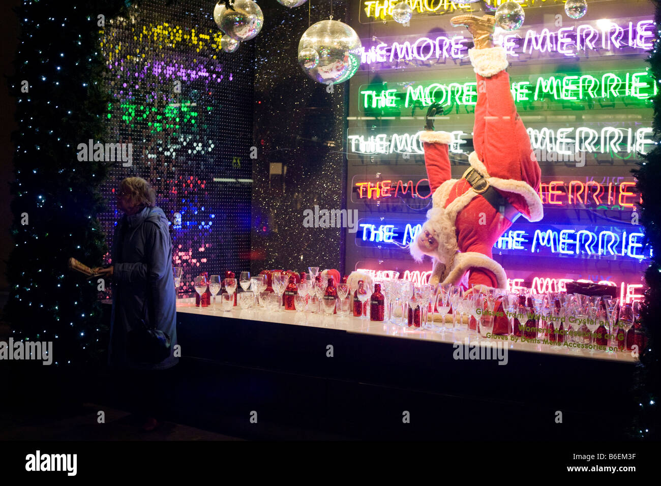 Eine Weihnachts-Shopper hält in der Nähe ein Weihnachtsmann in einem saisonalen Fenster des Kaufhauses Selfridges in der Oxford Street Stockfoto