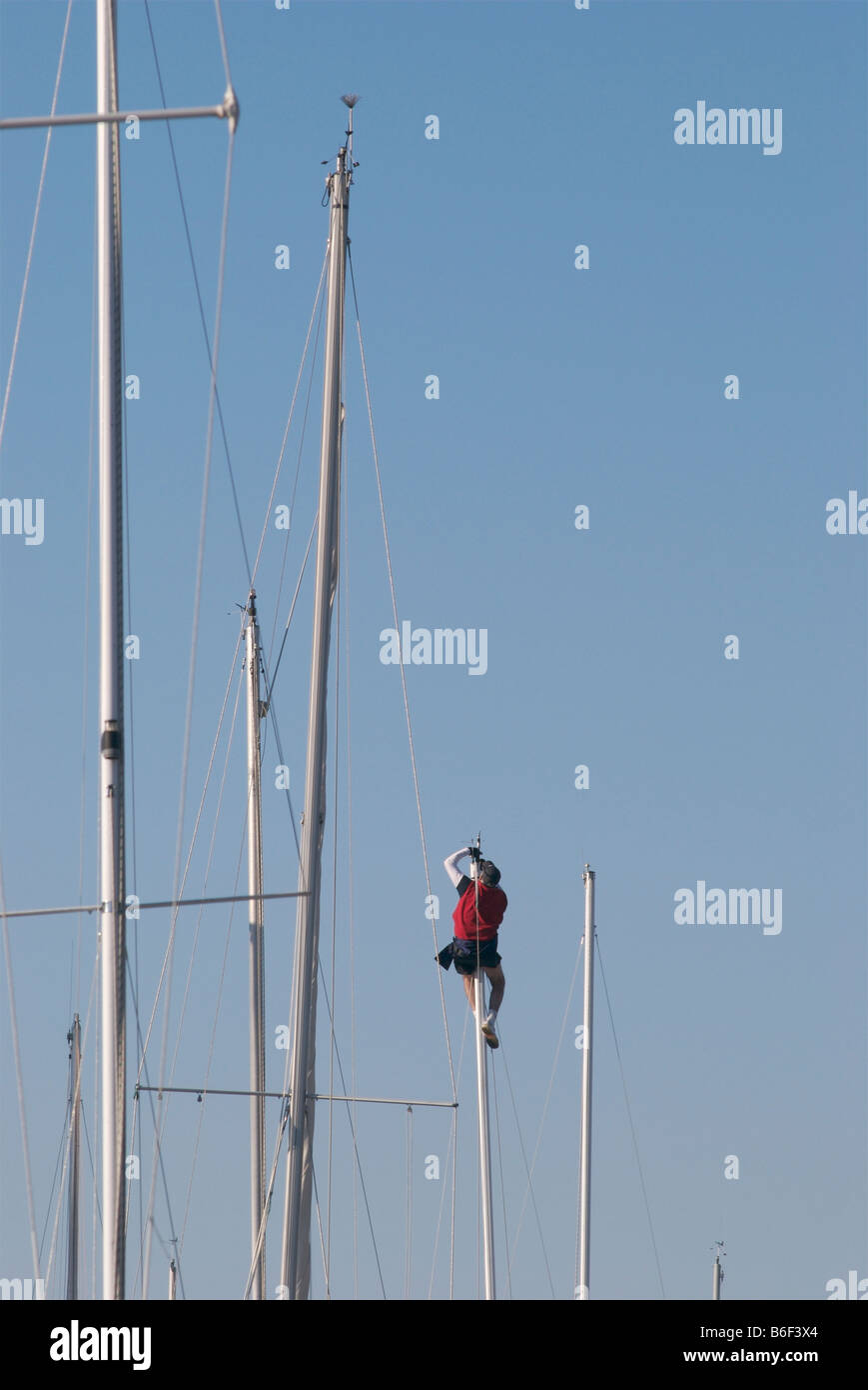 Seemann gehen oben in der Marina für Mast Top Arbeit. Stockfoto