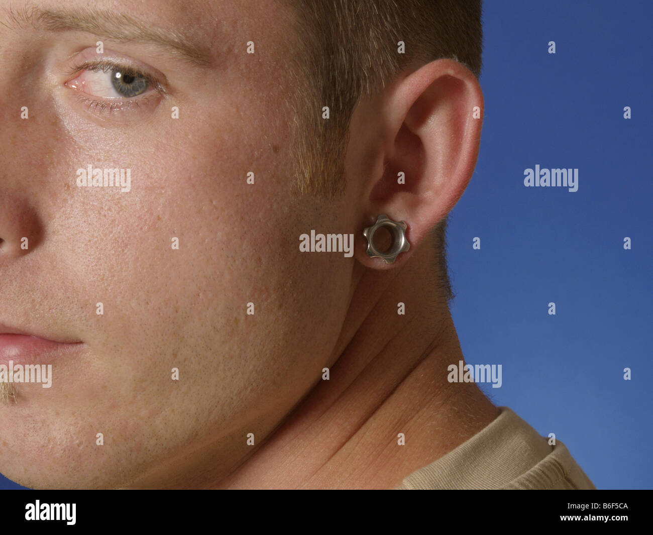 Porträt eines jungen Mannes mit Ohrenpiercing Stockfoto