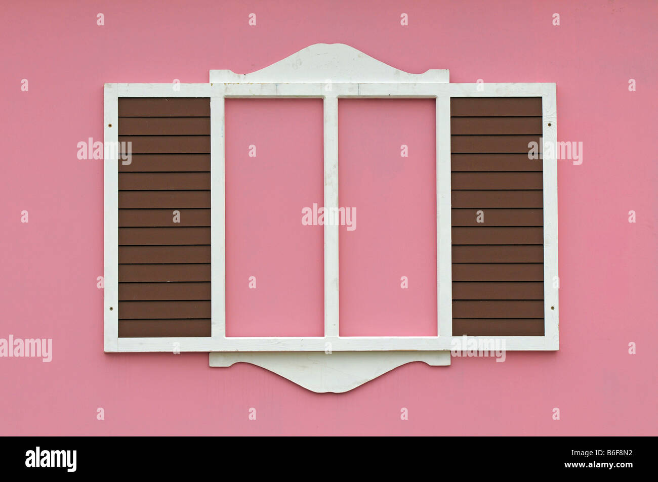 Stilisierte Fenster mit Fensterläden auf einem rosa Haus Stockfoto