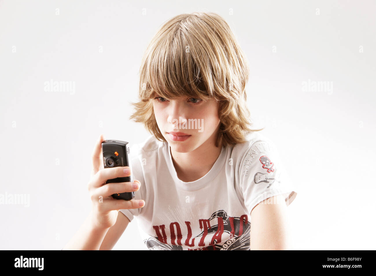 12 jähriger Junge spielt mit seinem Handy Stockfoto