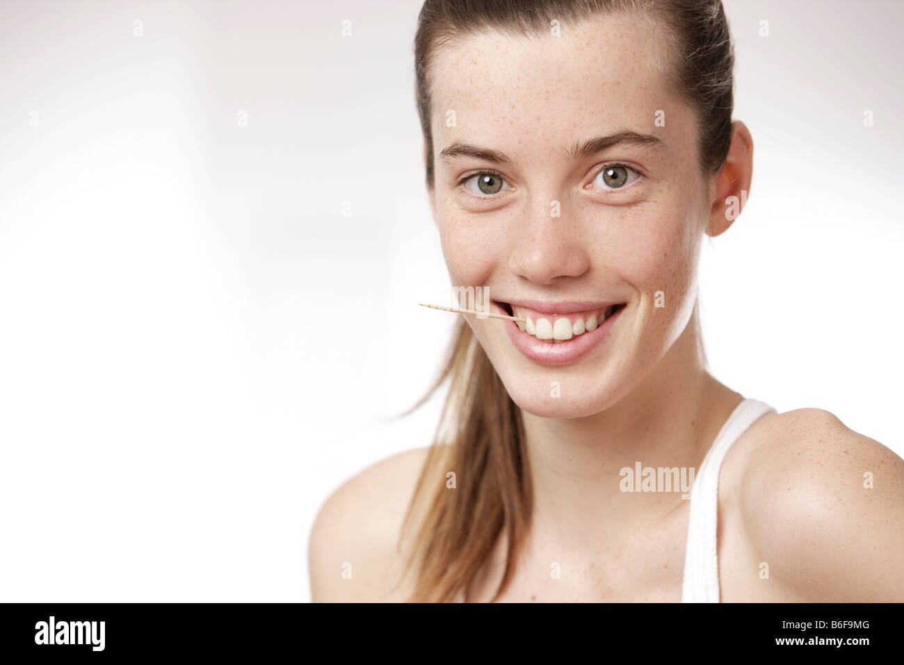 Teenager-Mädchen, Frau, mit einem Zahnstocher zwischen den Zähnen Stockfoto