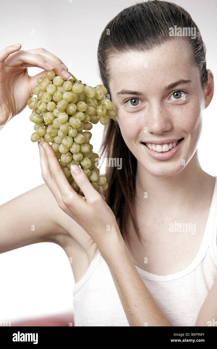 Teenager-Mädchen, Frau, 17 Jahre alt, hält eine Reihe von weißen Trauben Stockfoto
