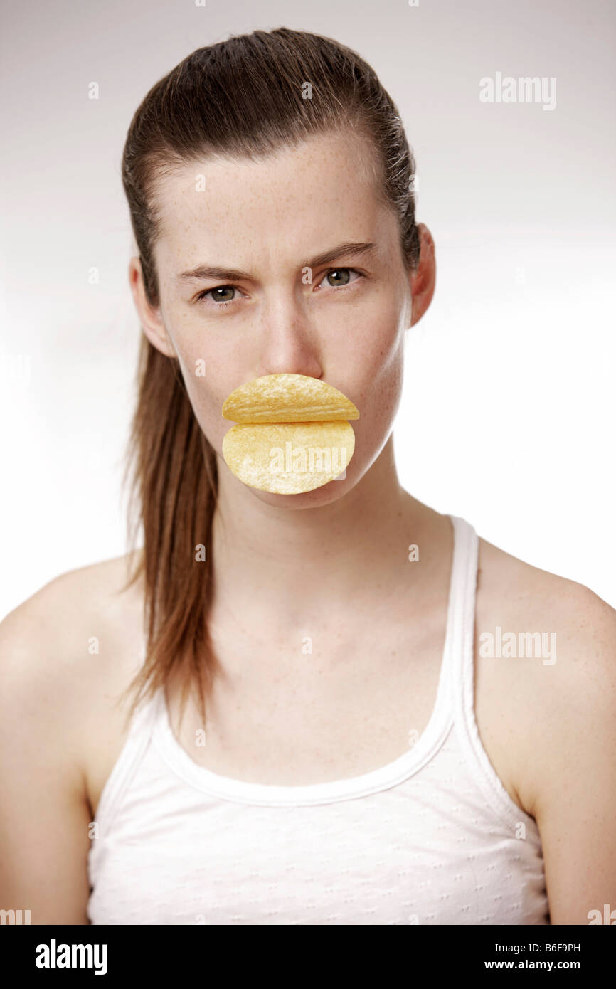 Teenager-Mädchen, Frau, 17 Jahre alt, Holding Chips als Lippen in den Mund Stockfoto