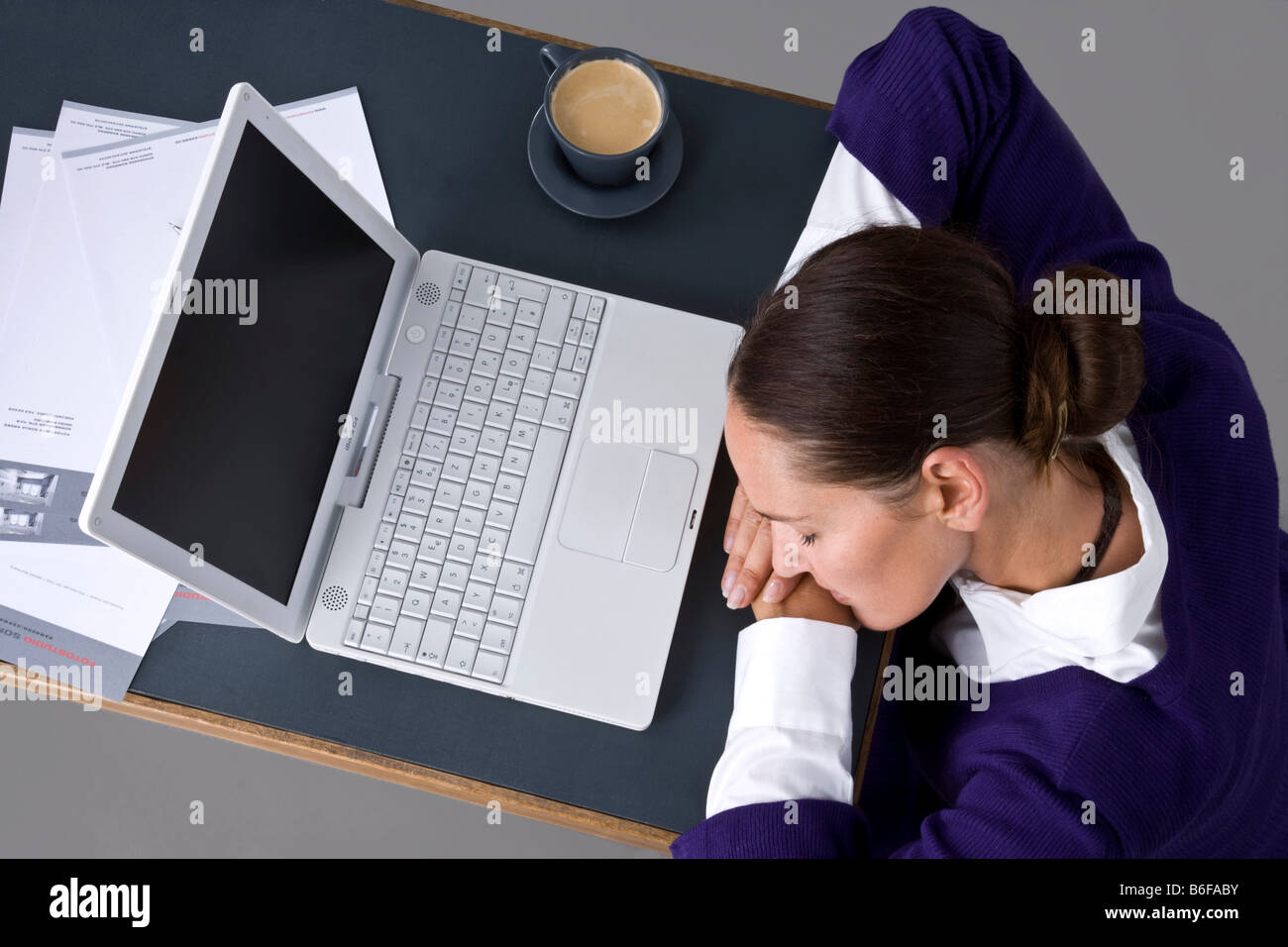 Junge Frau schläft auf einem computer Stockfoto