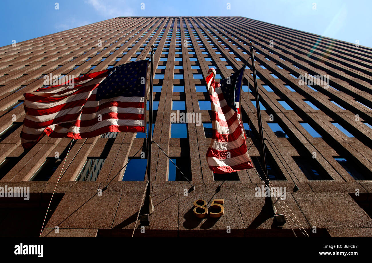Fassade eines Hochhauses mit US-Fahnen über dem Eingang bei Gegenlicht, New York City, USA Stockfoto