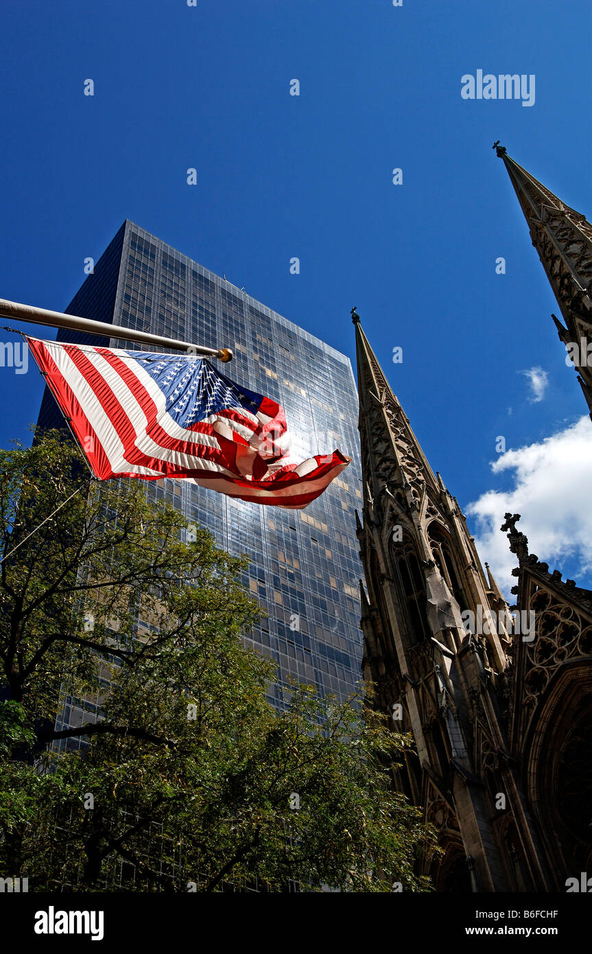 US-Flagge weht im Wind, Wolkenkratzer und St. Patricks Kathedrale Kirchtürme in den Rücken, New York City, USA Stockfoto