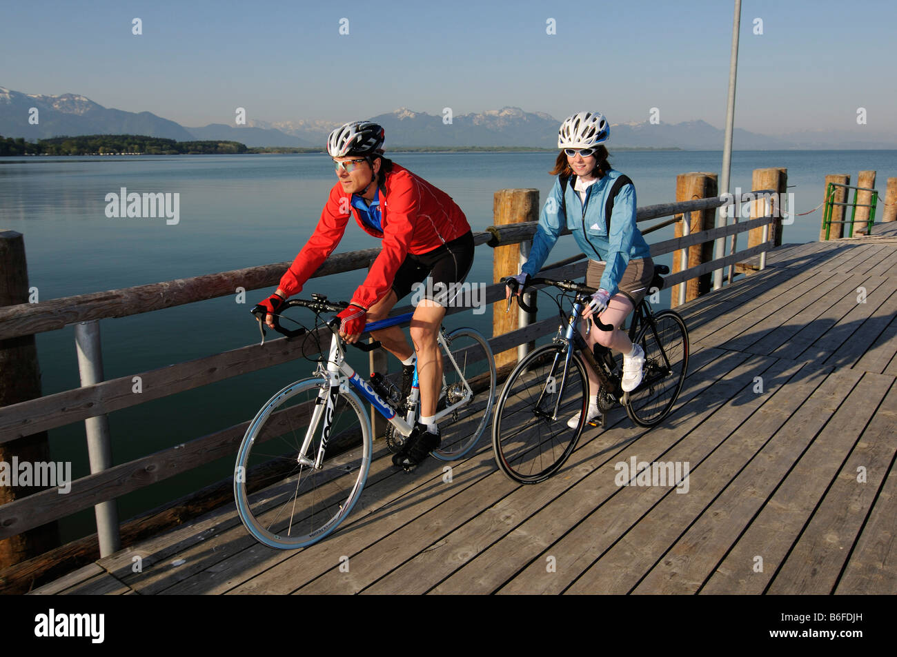 Rennradler auf dem Chieming Dampfer Steg am See Chiemsee, Chiemgau, Bayern, Deutschland, Europa Stockfoto