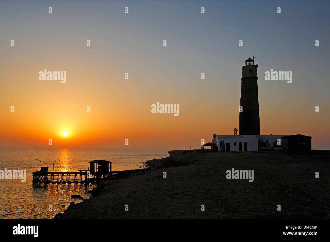 Leuchtturm und Mole, Silhouette und Sonnenuntergang über dem Ozean, Big Brother oder Akhawein-El-Kebir von den Brother Islands, Egy Stockfoto