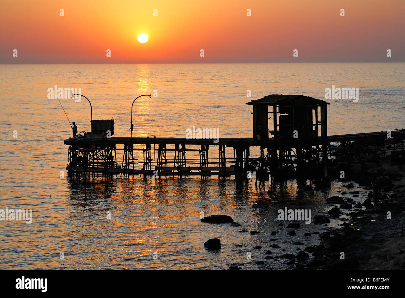 Pier-Silhouette bei Sonnenuntergang über dem Meer, felsige Küste von Big Brother The Brother Islands oder El Akhawein, Rotes Meer, Ägypten, Af Stockfoto