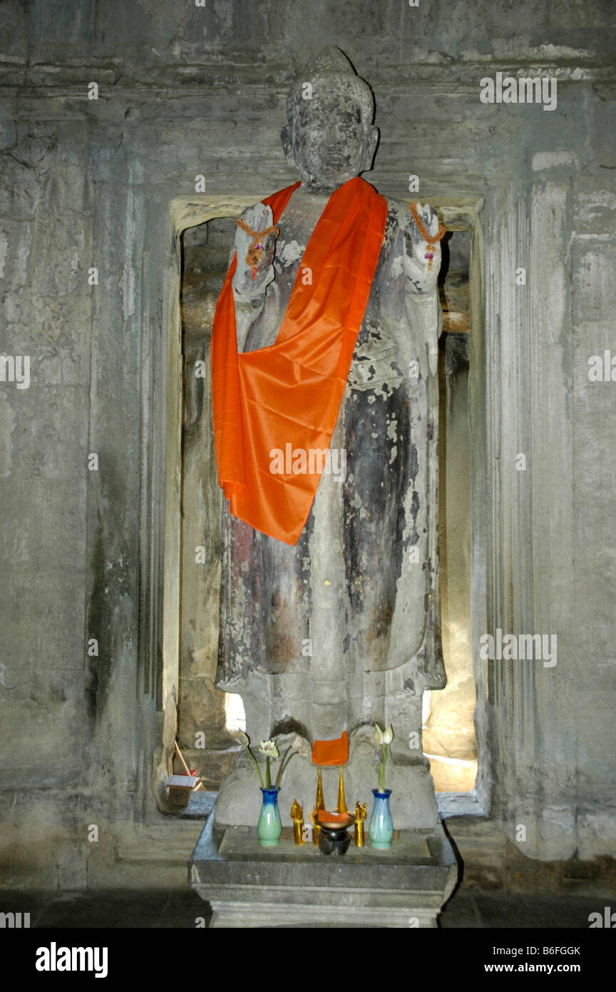 Alte Statue eines stehenden Buddha trägt eine orange Kap, Tempel von Angkor Wat, Siem Reap, Kambodscha, Südost-Asien Stockfoto