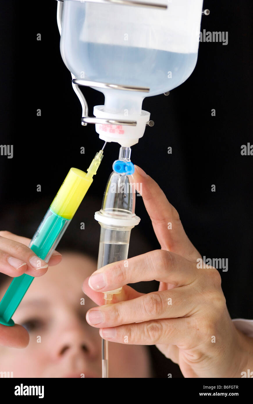 Arzt eine Infusion durch Einspritzen von Medizin in der Infusion vorbereiten Stockfotografie Alamy