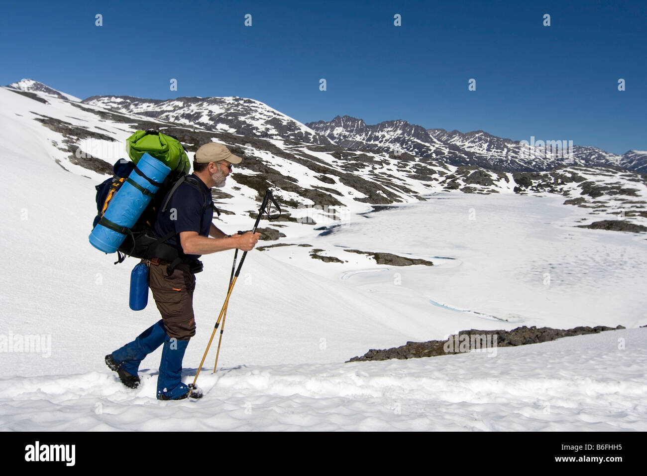Wanderer mit Rucksack durchqueren eine Schnee Feld, Chilkoot Trail, Chilkoot Pass, Britisch-Kolumbien, b.c., Kanada, Nordamerika Stockfoto