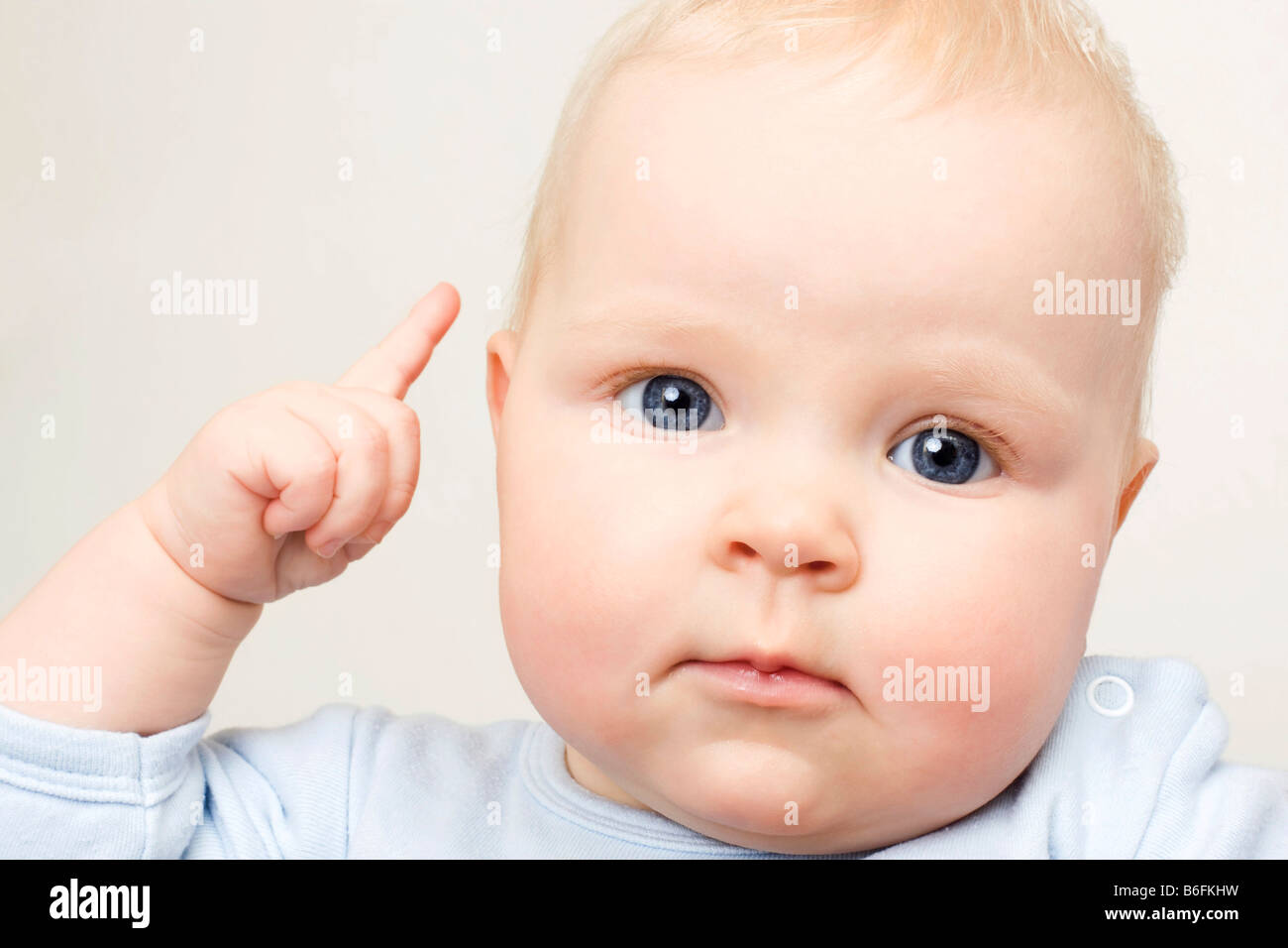 Baby, 7 Monate alt, mit einem Finger auf, Porträt Stockfoto