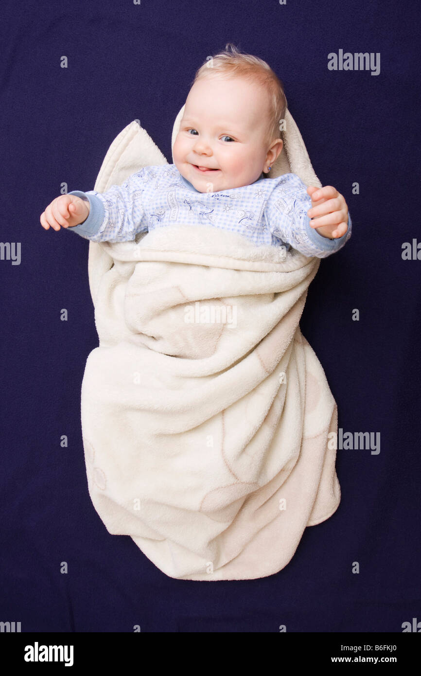 Smiling Baby, 7 Monate alt, in eine Decke gehüllt Stockfoto