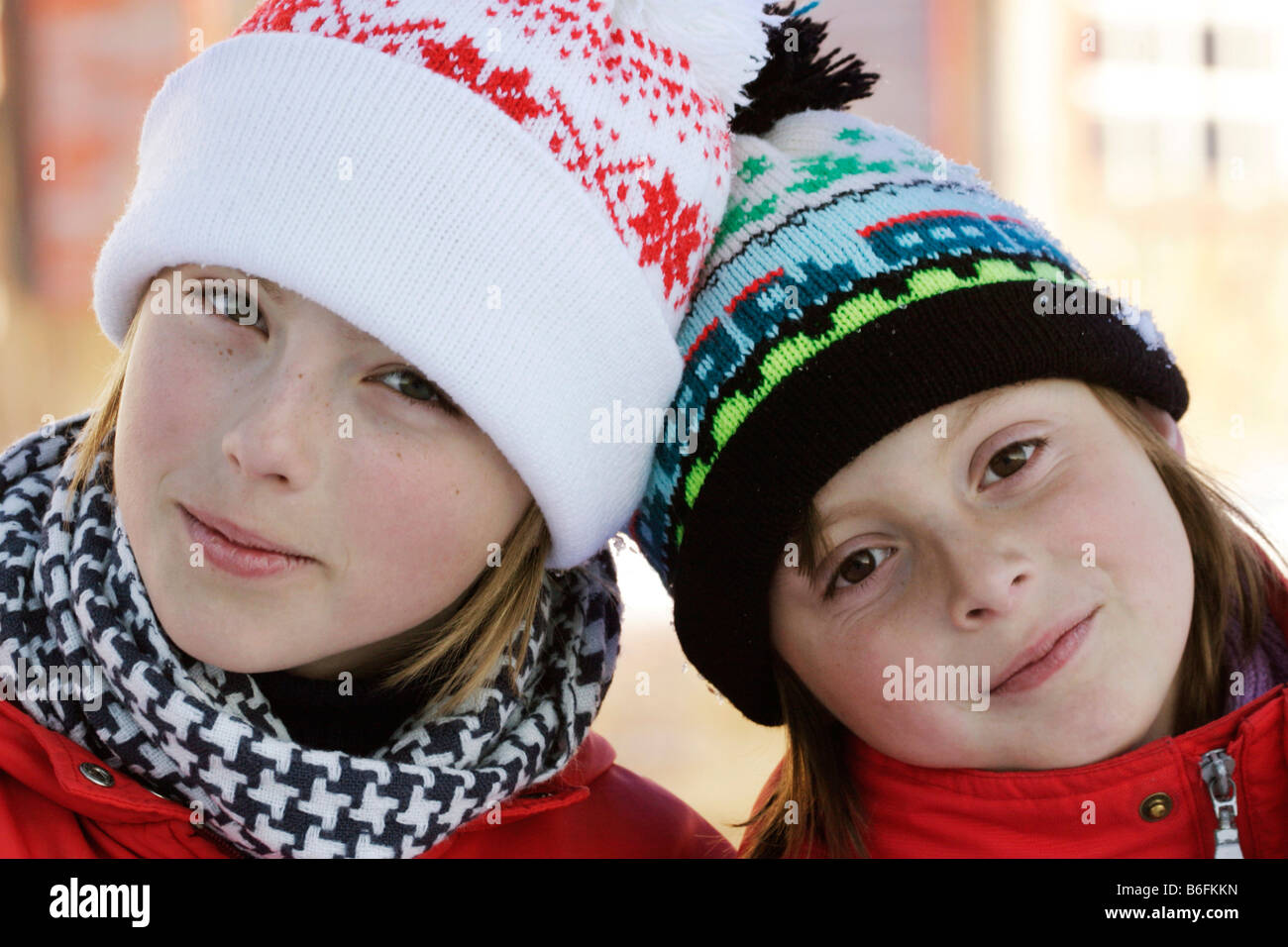 Zwei Schwestern, 9 und 12 Jahre alt, mit wollenen Mützen im Außenbereich Stockfoto