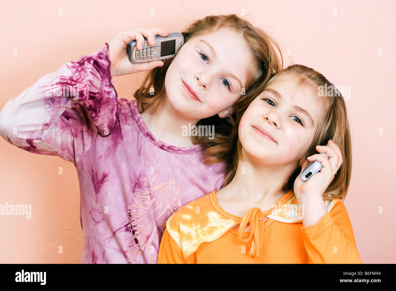 Zwei kleine Mädchen, 9 und 6 Jahre, telefonieren Stockfoto