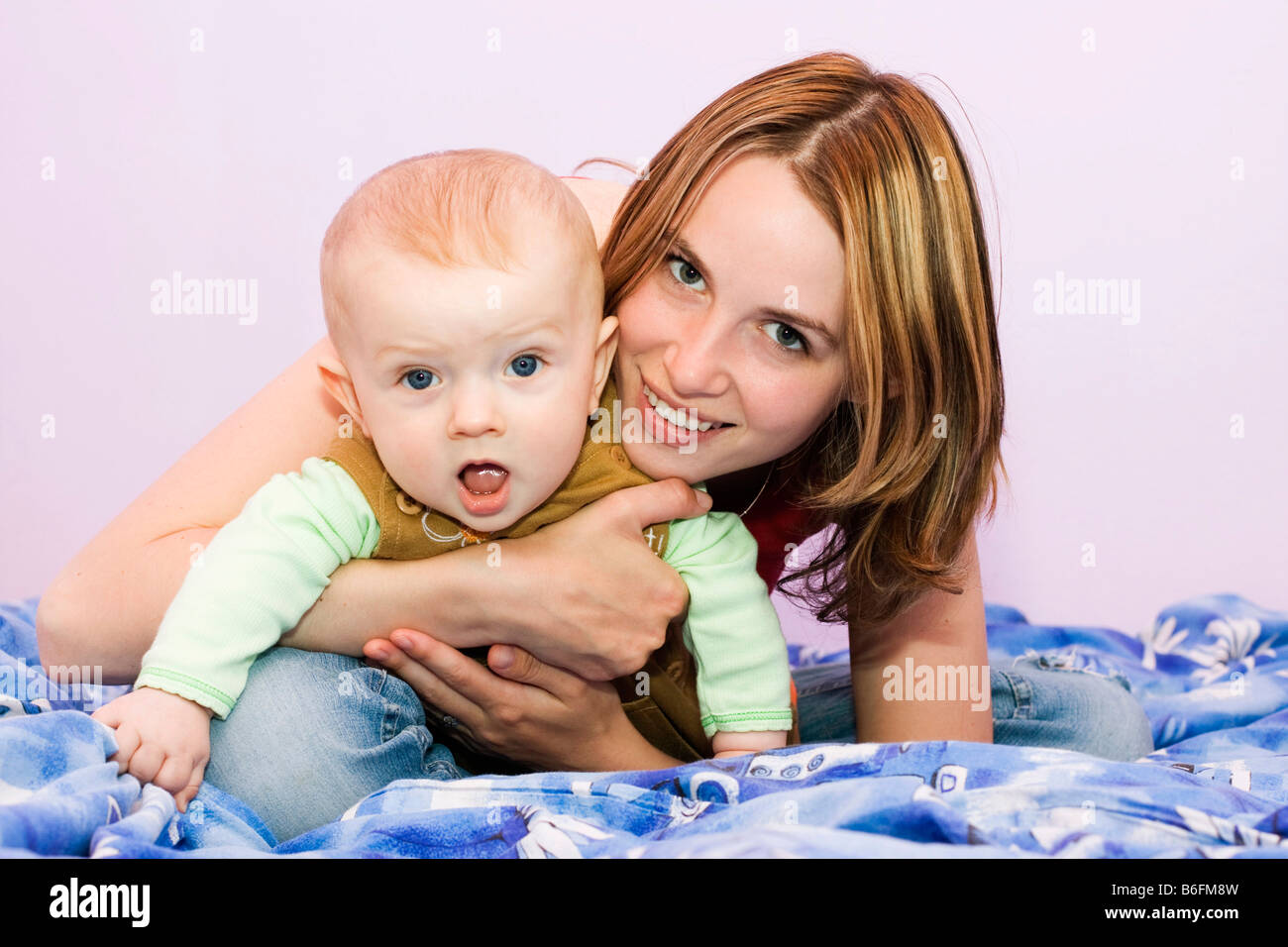 Lächelnde junge Mutter, 25 Jahre alt, und ihr Sohn, 7 Monate alt Stockfoto