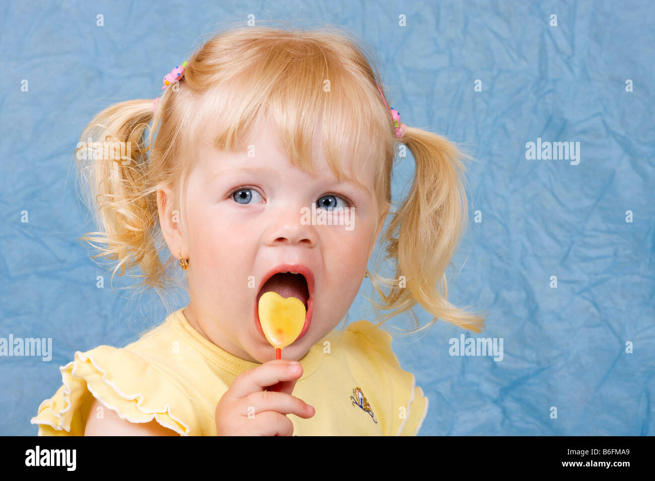 Blonde Mädchen, 2 Jahre, mit lollipop Stockfoto