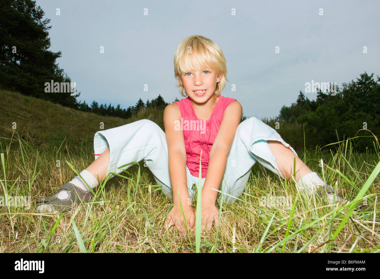 Mädchen, 7 Jahre alt, sitzt in der Natur Stockfoto