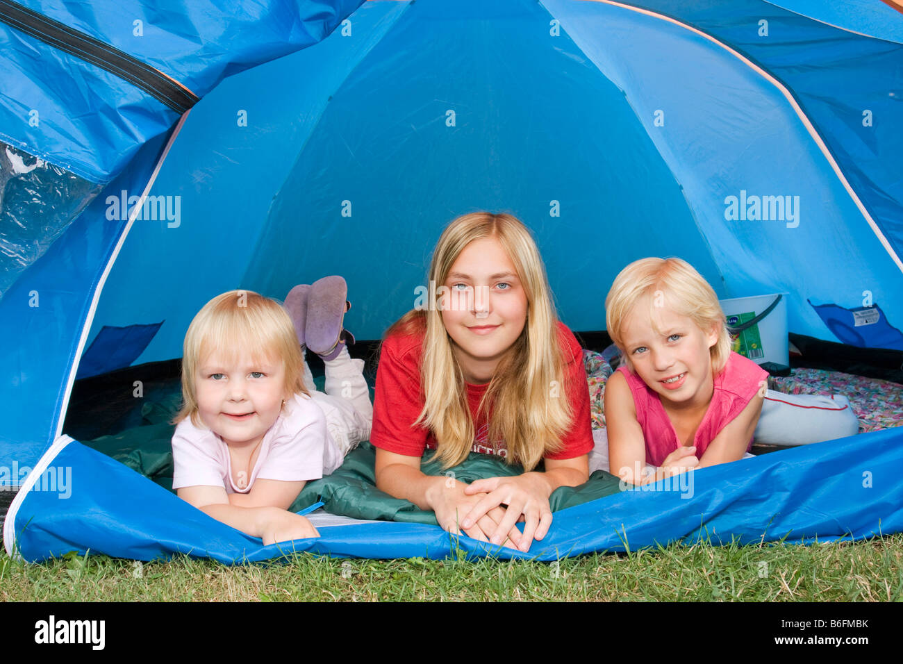 Drei Schwestern, 5 Jahre, 13 und 7 Jahre alt, im Zelt Stockfoto