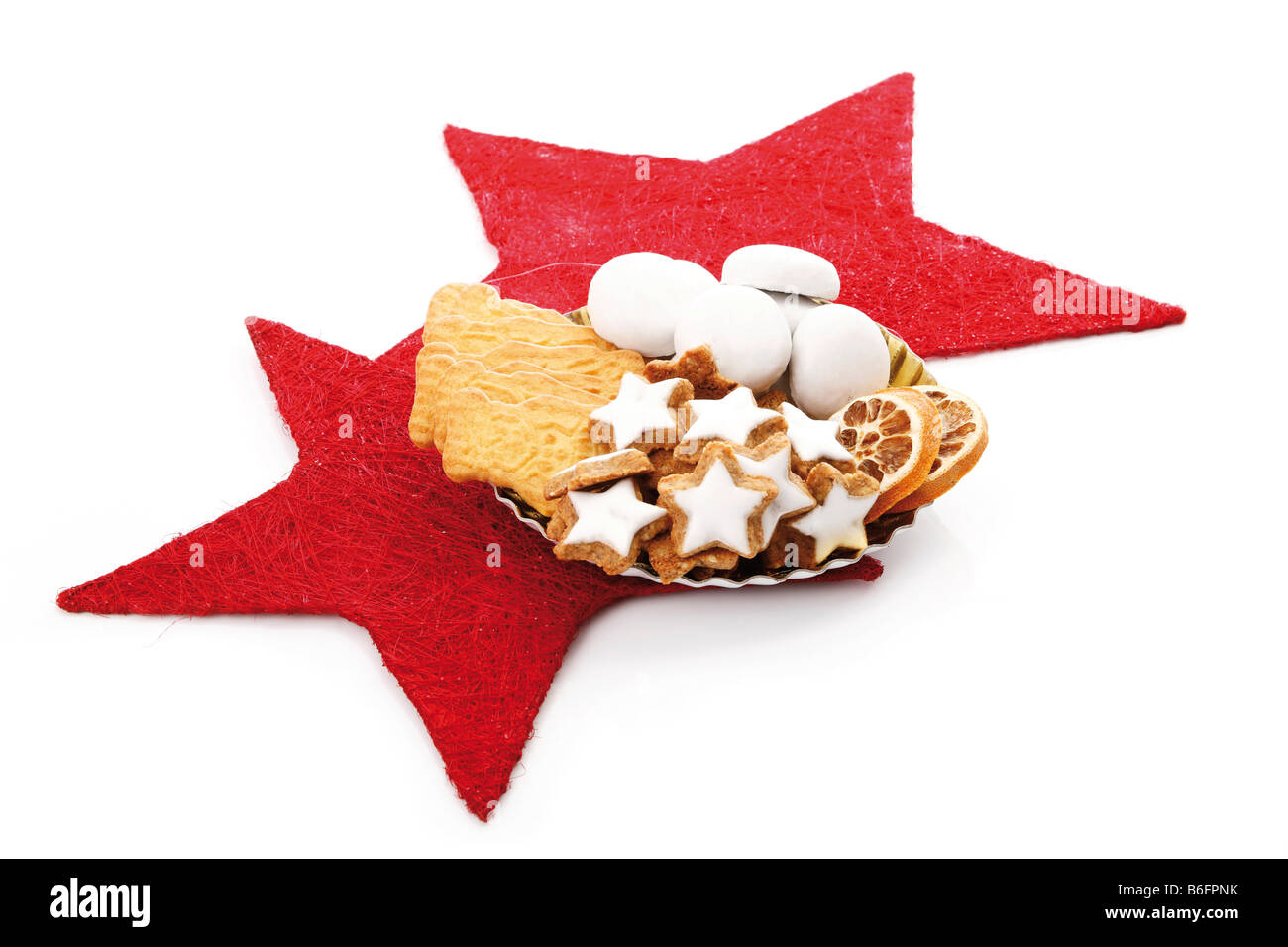 Teller mit Assortmed Weihnachtsgebäck auf roten Sternen Dekoration, sternförmige Zimtgebäck, gewürzte Kekse, Lebkuchen bisc Stockfoto