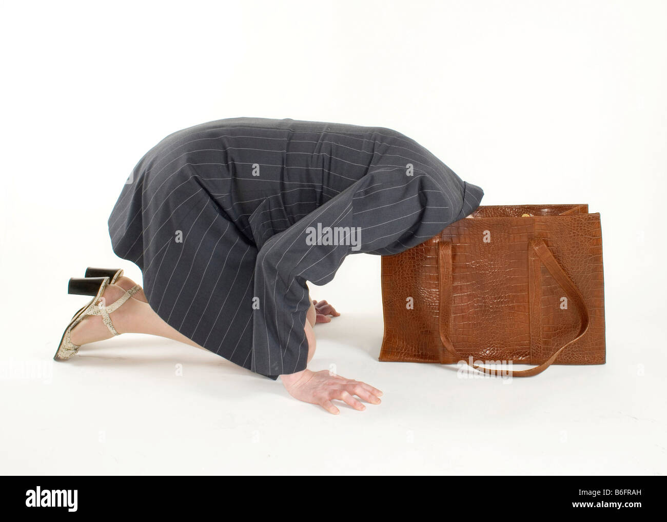 Frau, die ihren Kopf in ihre Handtasche stecken Stockfoto