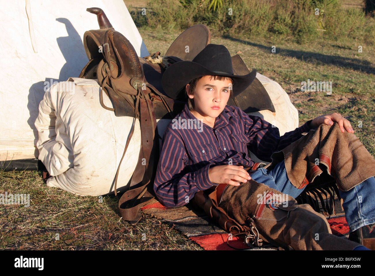 Ein junger Cowboy an seinem Bett Roll auf der Palette Stockfoto