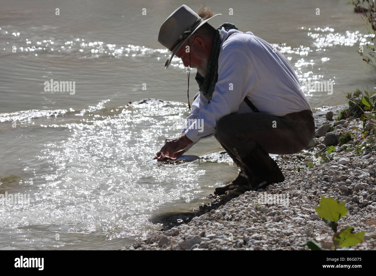 Ein Anspruch Bagger Goldwaschen in einem Stream in Texas das Licht ist aus dem Wasser in der Pfanne shinning Stockfoto