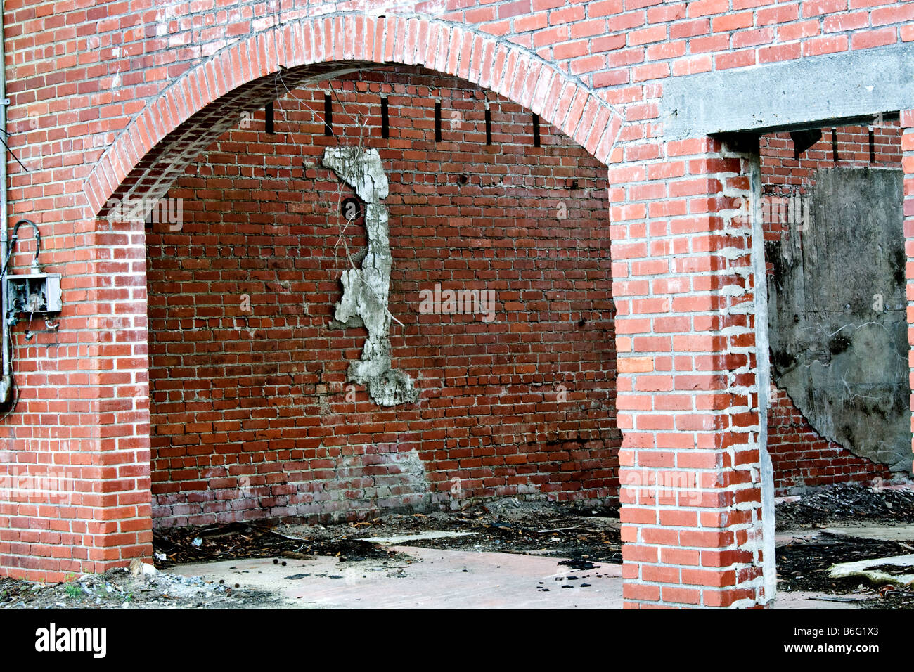 Torbogen von einem alten unbewohnten verfallenden Backsteinhaus Stockfoto