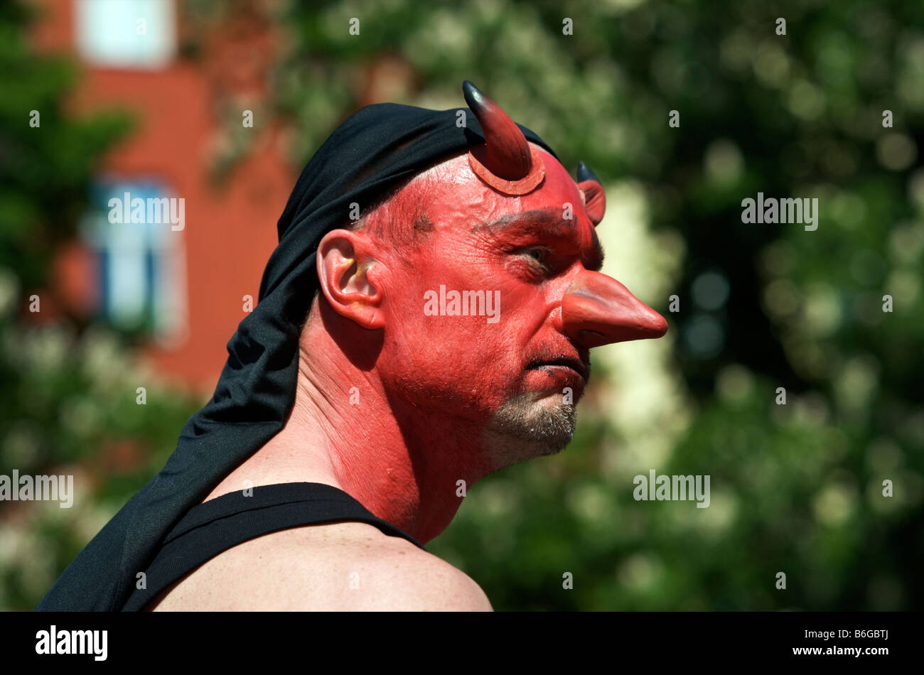 Mann mit rotem Gesichtsmaske mit Teufelshörnern und große Nase Stockfoto