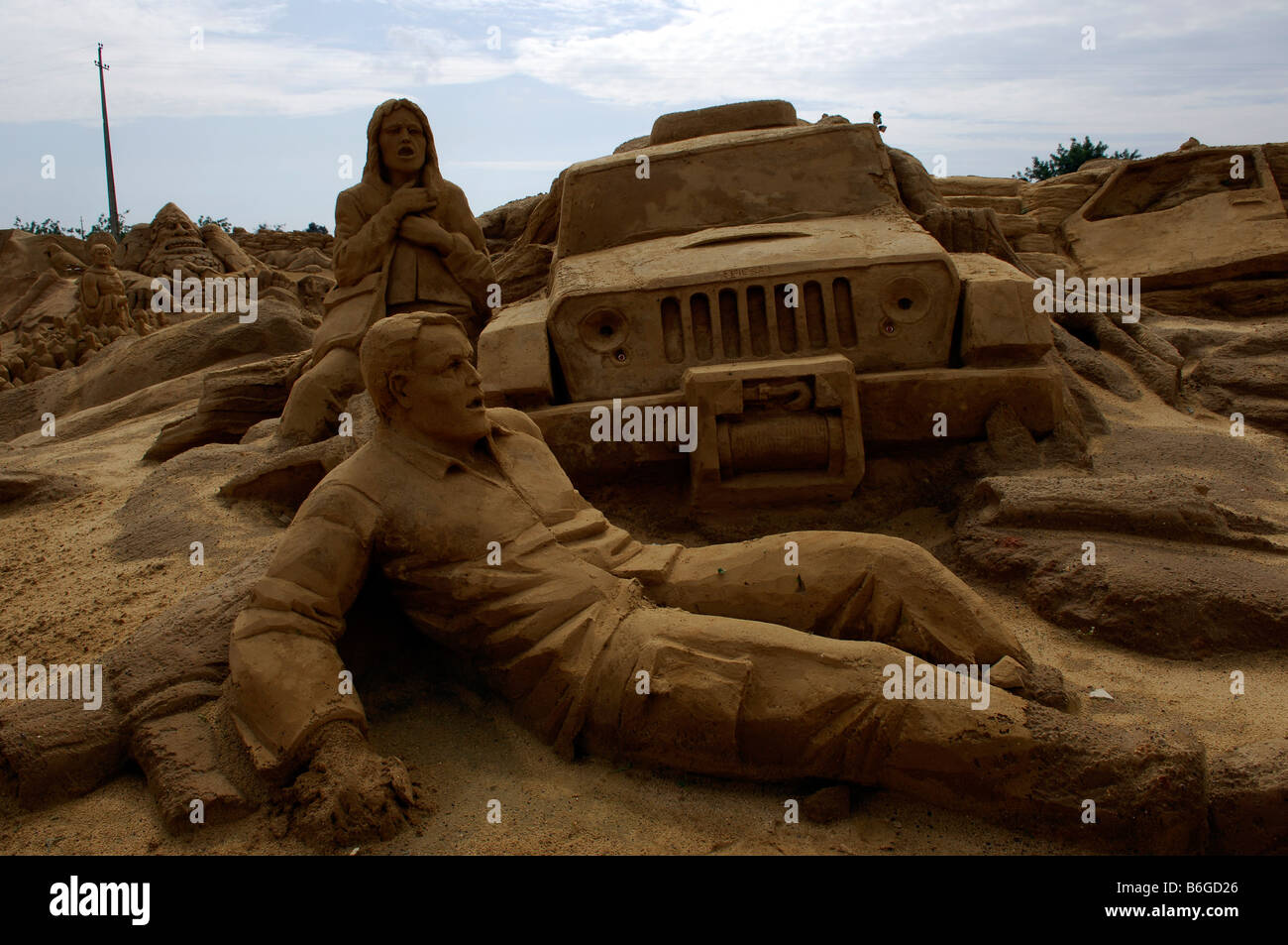 Mann liegend vor Jeep Sand Kunst Stockfoto