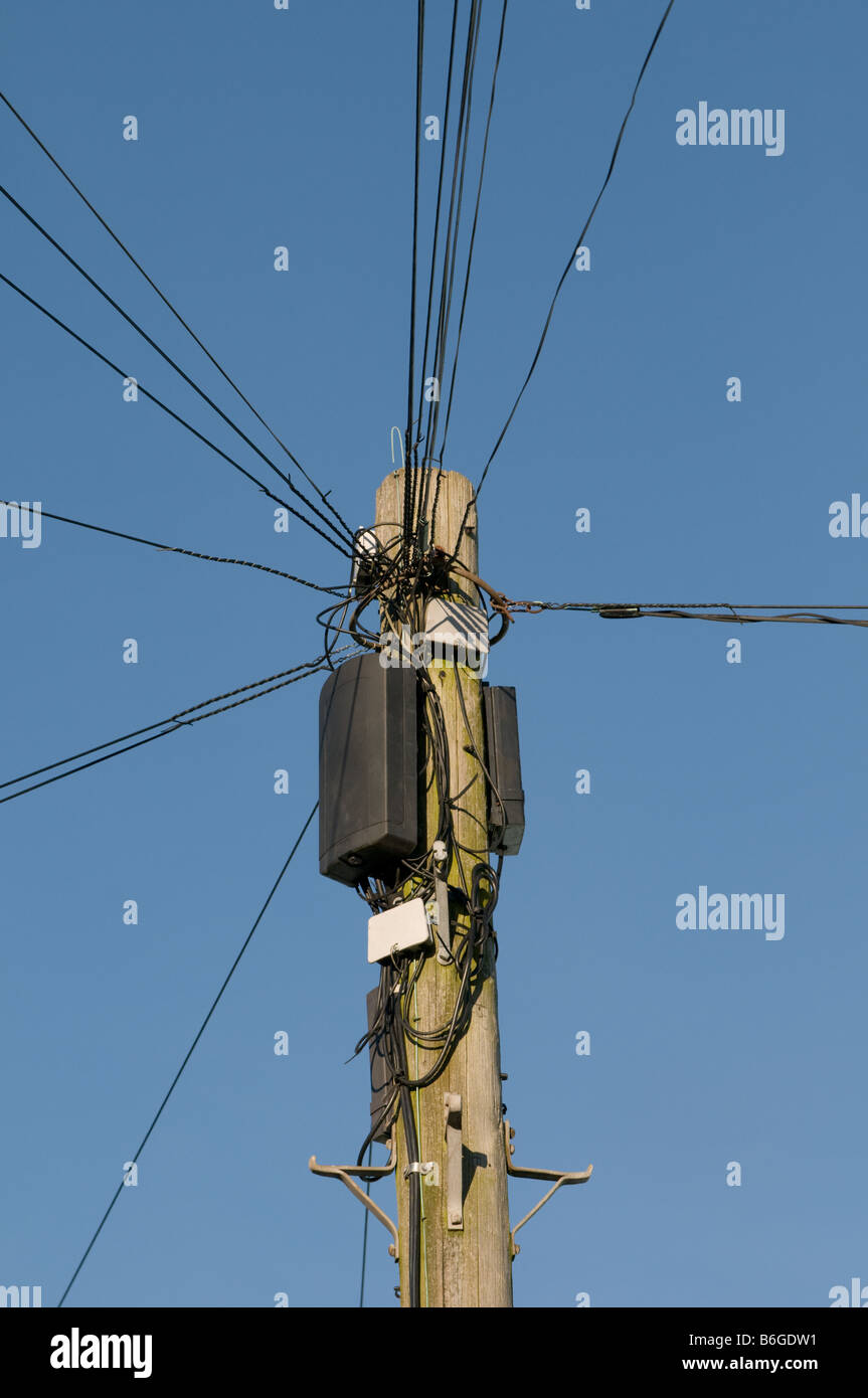 Telefonleitungen strahlenden heraus von der Spitze des einen Telegrafenmast vor blauem Himmel UK Stockfoto