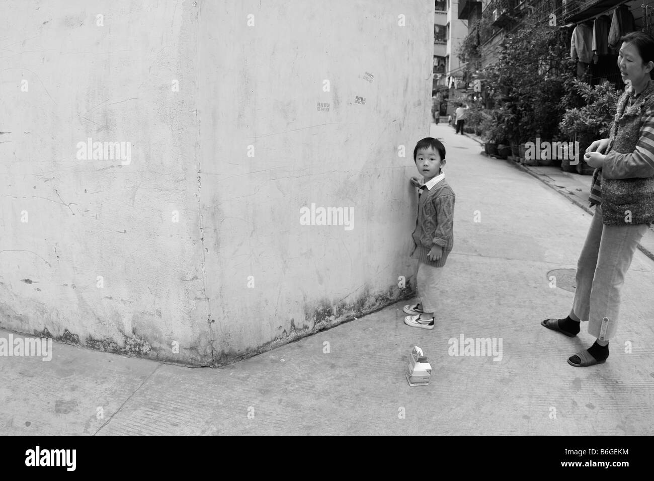 Junge chinesische Kind Zahlen außerhalb Malen von Bildern auf Wand Stockfoto