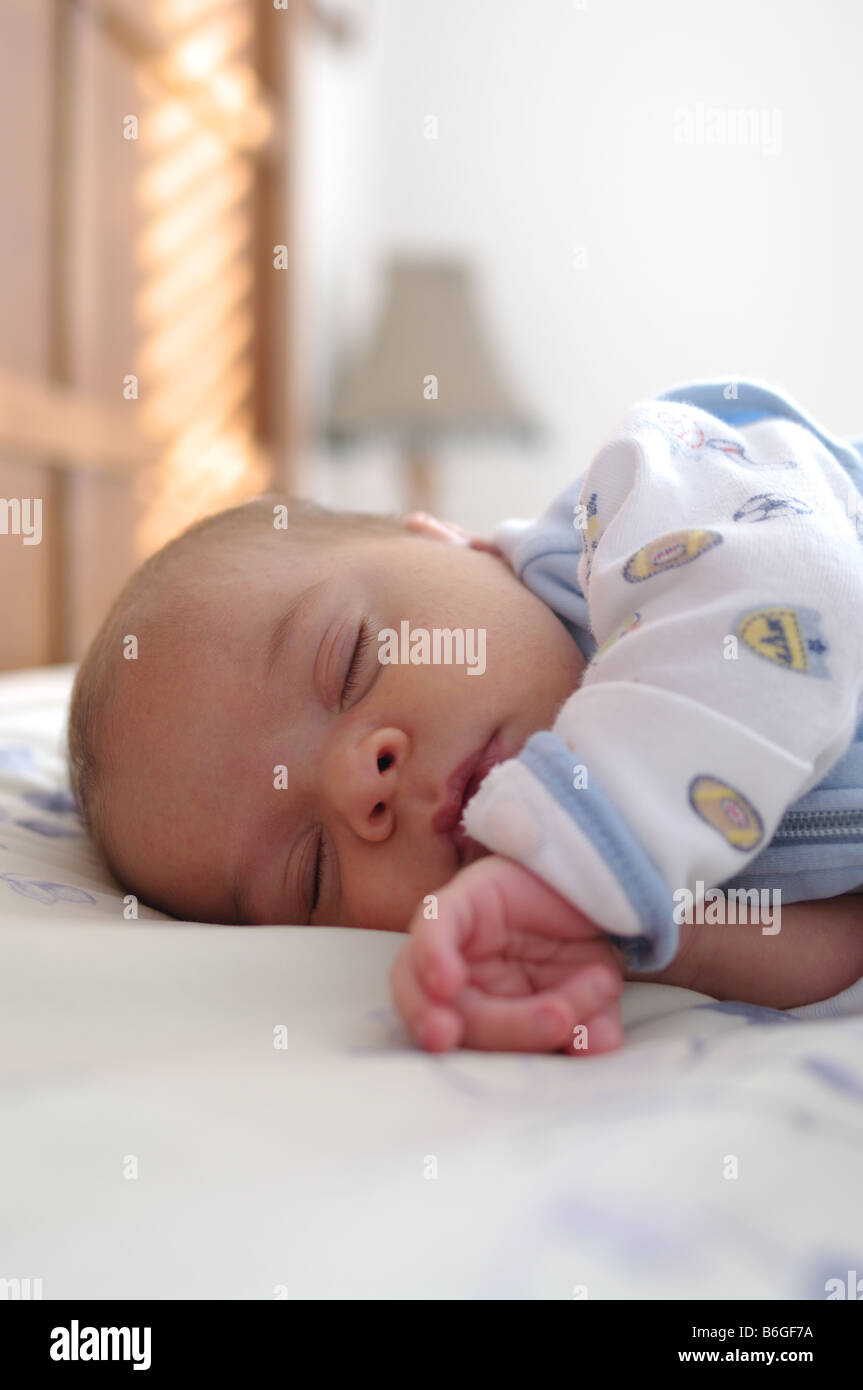 0-3 Monate alten Baby junge schlafen im Bett der Eltern Stockfoto