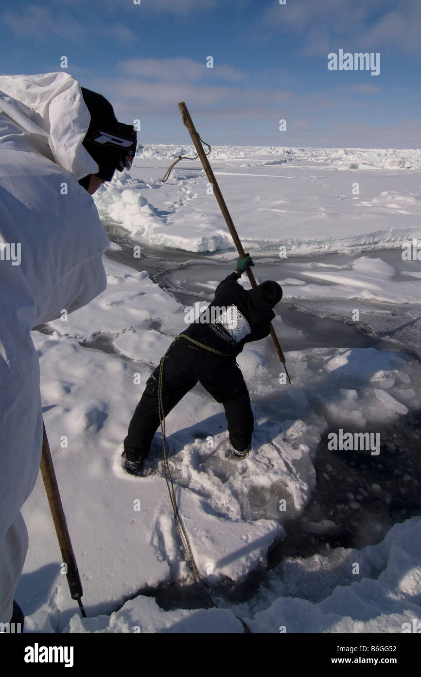 Inupiaq Walfänger öffnen ein Loch in das Packeis für potentielle Tierwelt Tschuktschensee passieren Stockfoto
