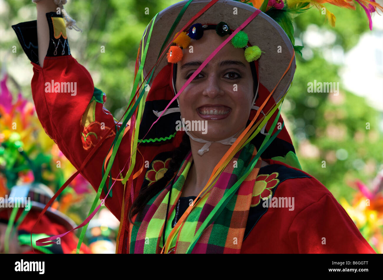 Lachende Mädchen im roten Kostüm mit Hut und Bändern Stockfoto