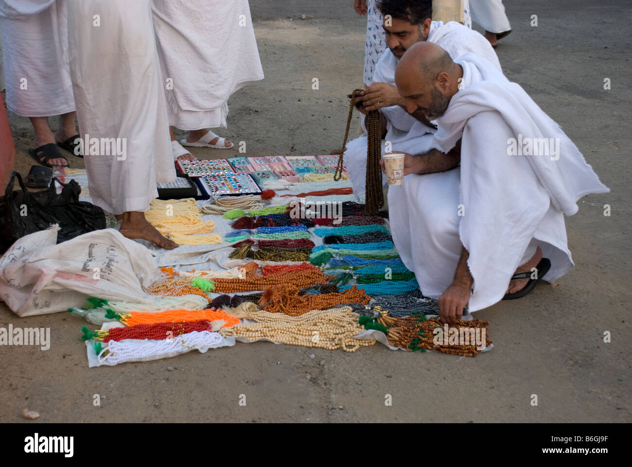 Zwei muslimische Pilger betrachten Gebetskette bei Straßenverkäufern Makkah Saudi Arabien Stockfoto