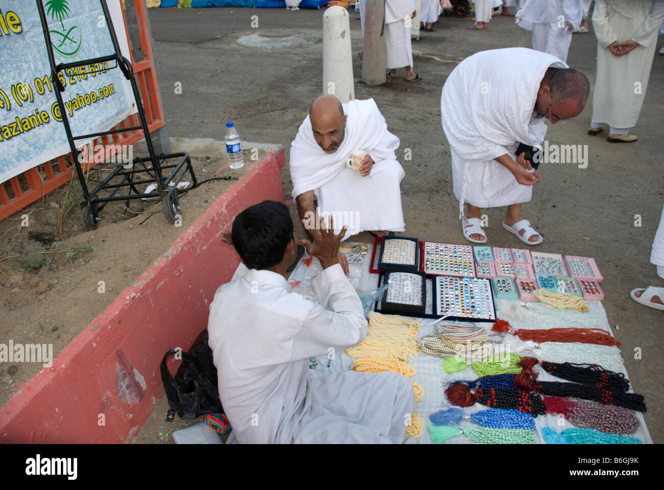 Zwei muslimische Pilger betrachten Gebetskette und Ringe an Straßenverkäufer Makkah Saudi Arabien Stockfoto