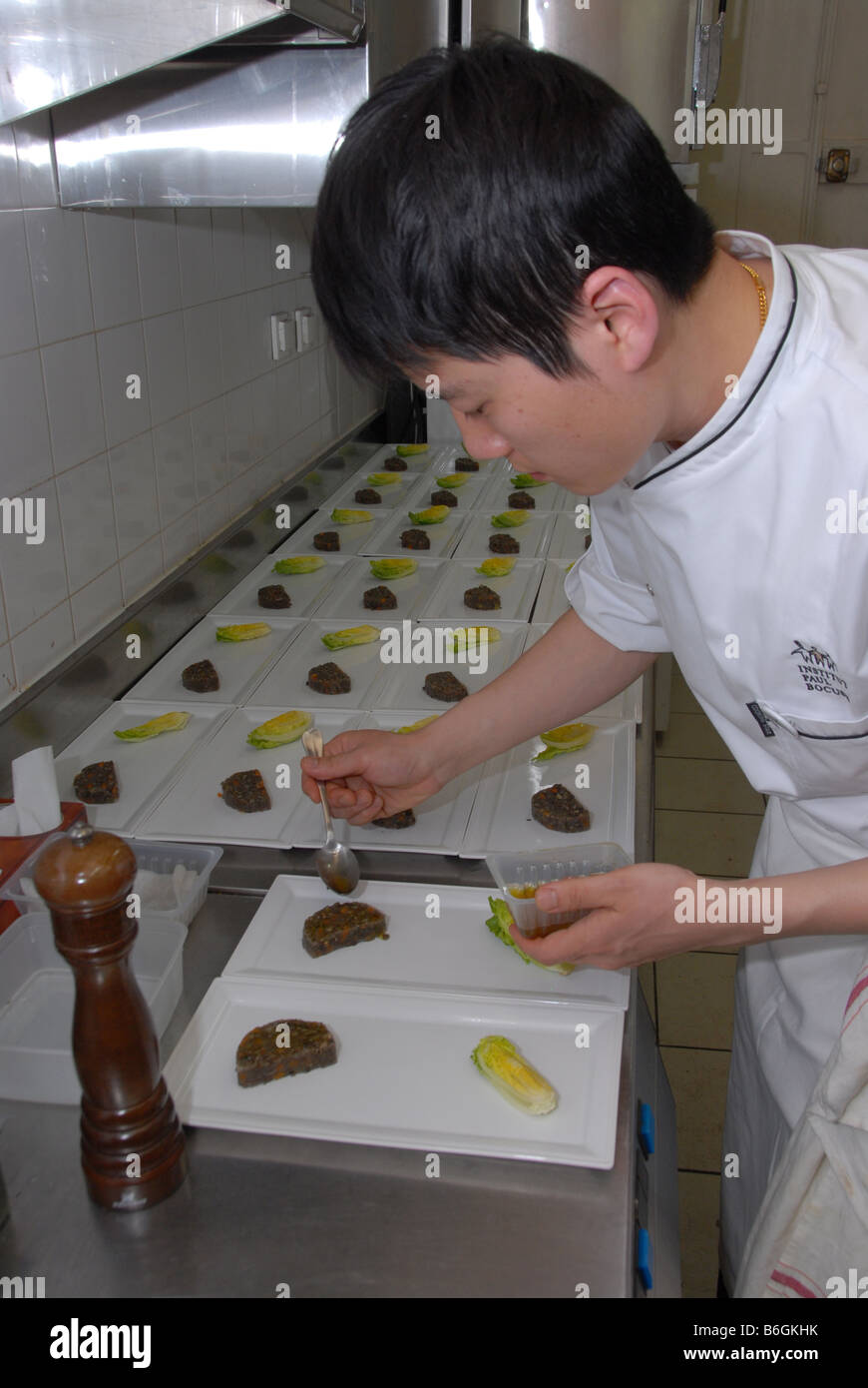 Ein japanischer Koch Mitglied des Institut Paul Bochuse Köche in einer belebten Küche in Lyon, Frankreich. Lyon ist gastronomische Hauptstadt. Stockfoto