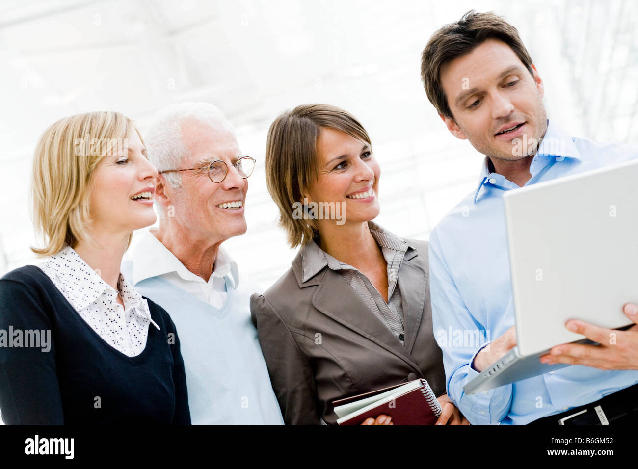 4 Personen, Blick auf laptop Stockfoto