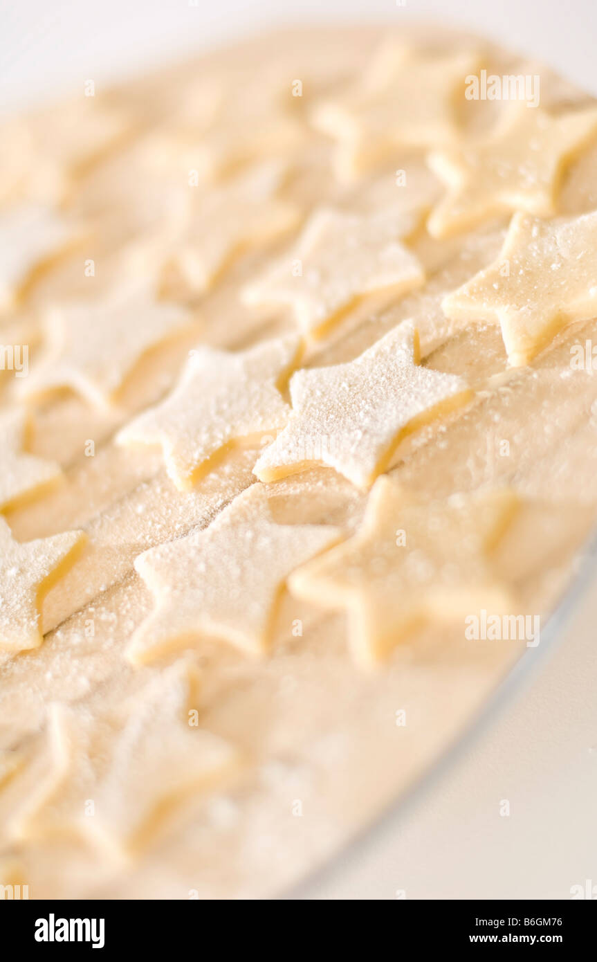 Sternförmige Ingwer Kekse gelegt auf Fett-Proof Papier vor dem Kochen. Dann verpackt in kleine Kisten für Weihnachtsgeschenke. Stockfoto