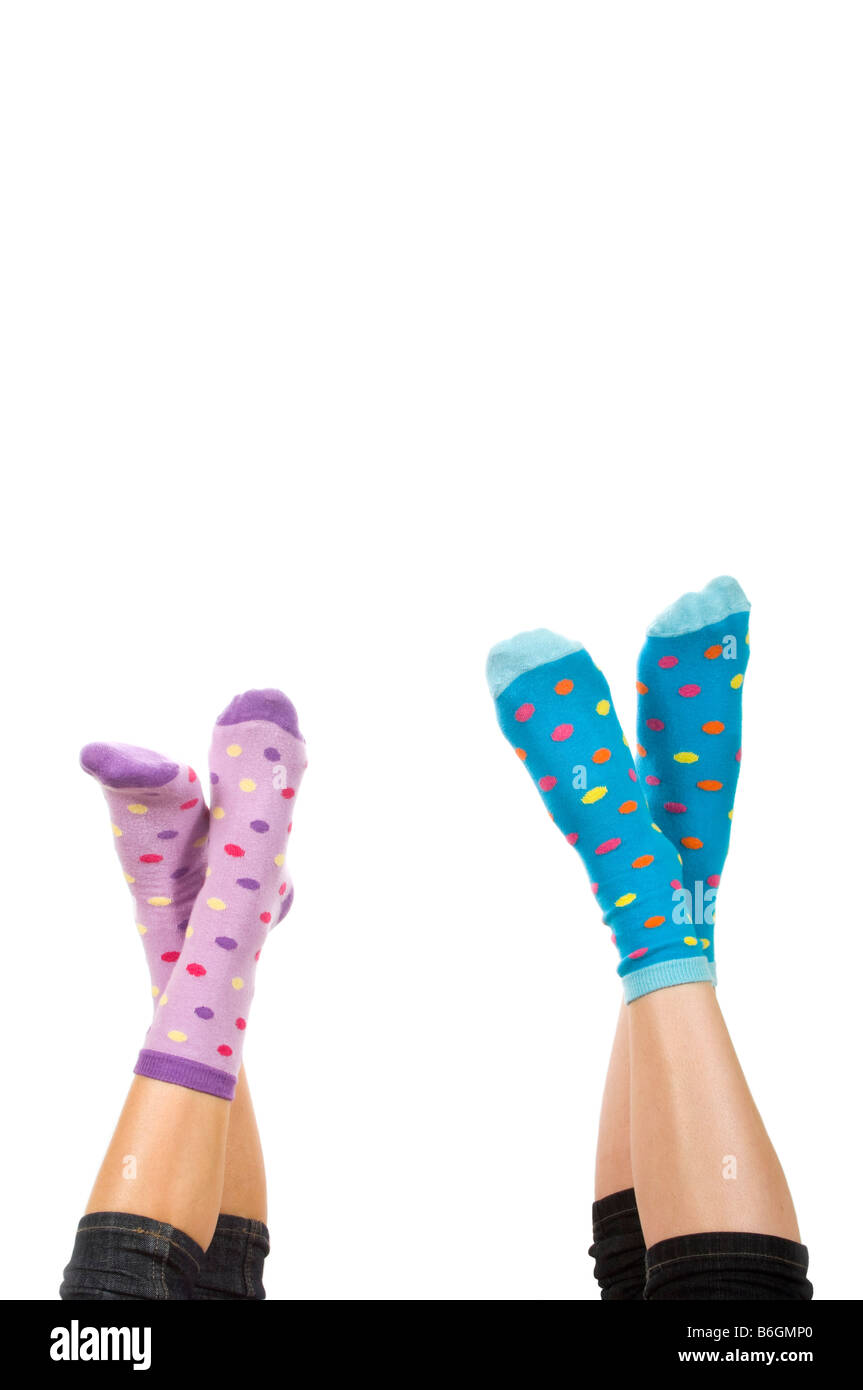 Vertikal nah Porträt aus zwei gekreuzten Füßen tragen nicht so doll Socken in die Luft vor einem weißen Hintergrund Stockfoto