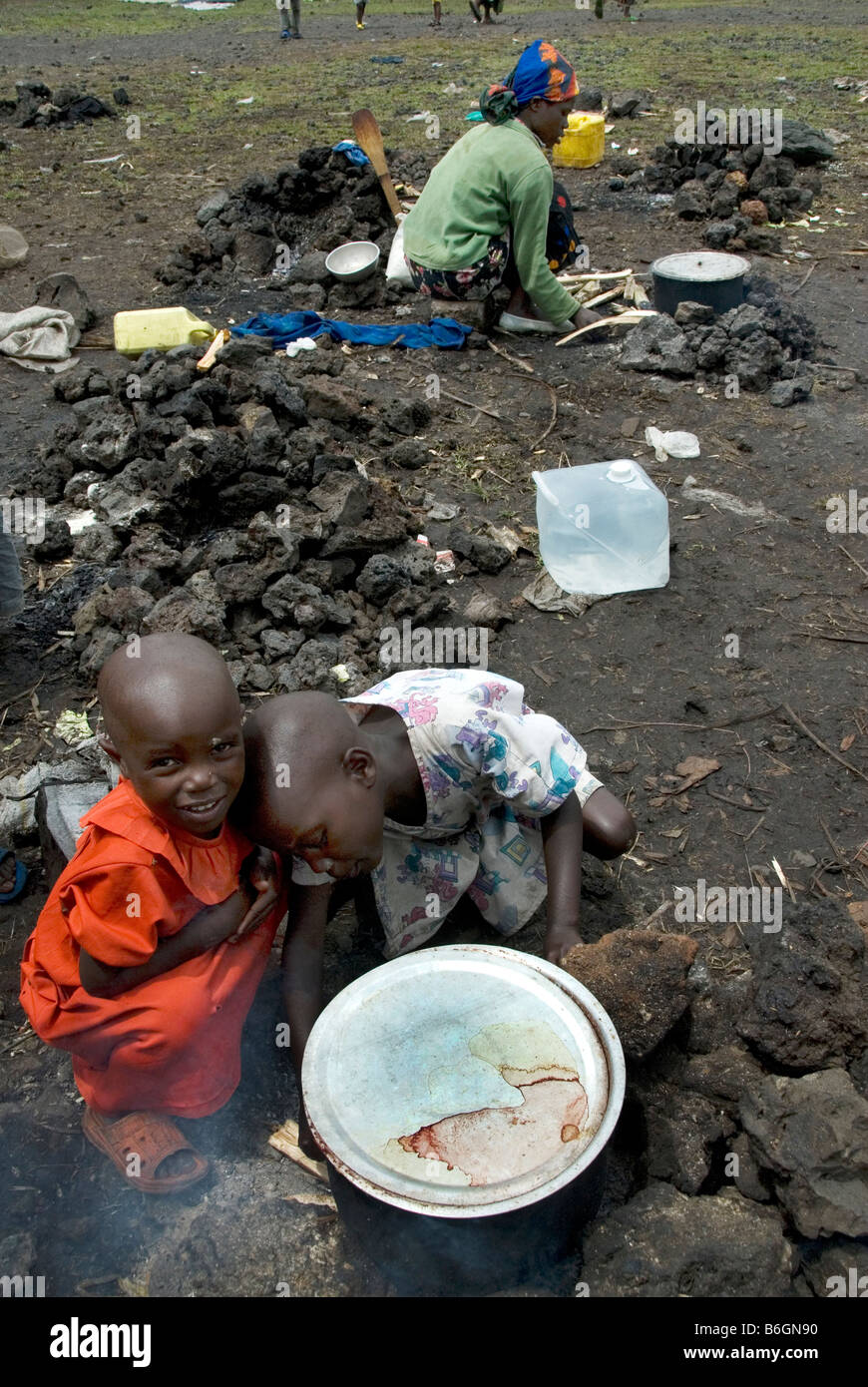 Goma DRK Kibati Lager für Vertriebene November 22. 2008 Umbere im Alter von 4 (Orange) und Rusi im Alter von 5 kochen Abendessen Stockfoto
