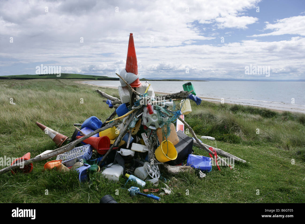 Ein großer Haufen Müll mit Strand und Meer im Hintergrund Stockfoto