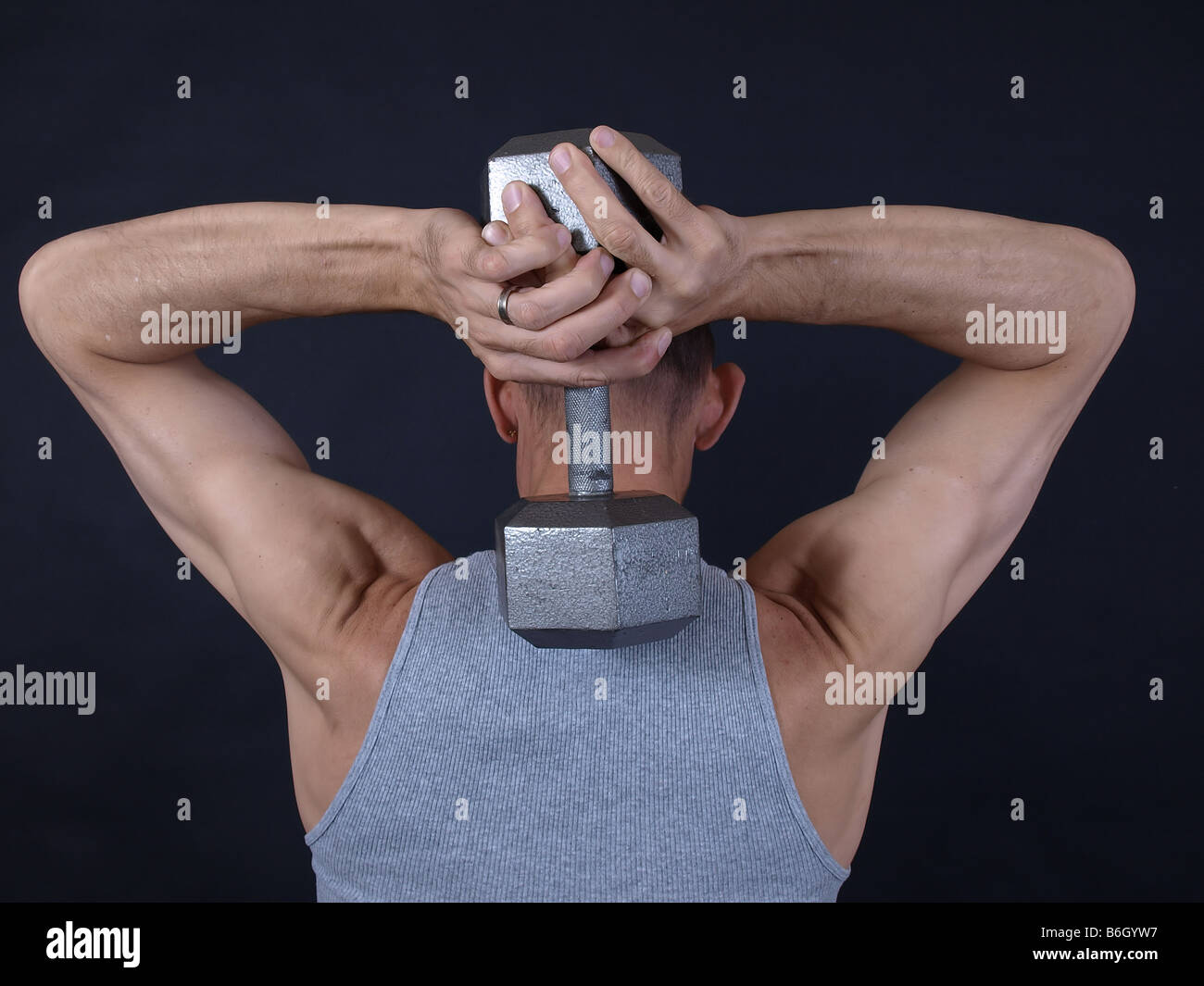 Ein Mann hält eine Gewicht hinter seinem Kopf arbeitet, seine Arme und  Schultern Stockfotografie - Alamy