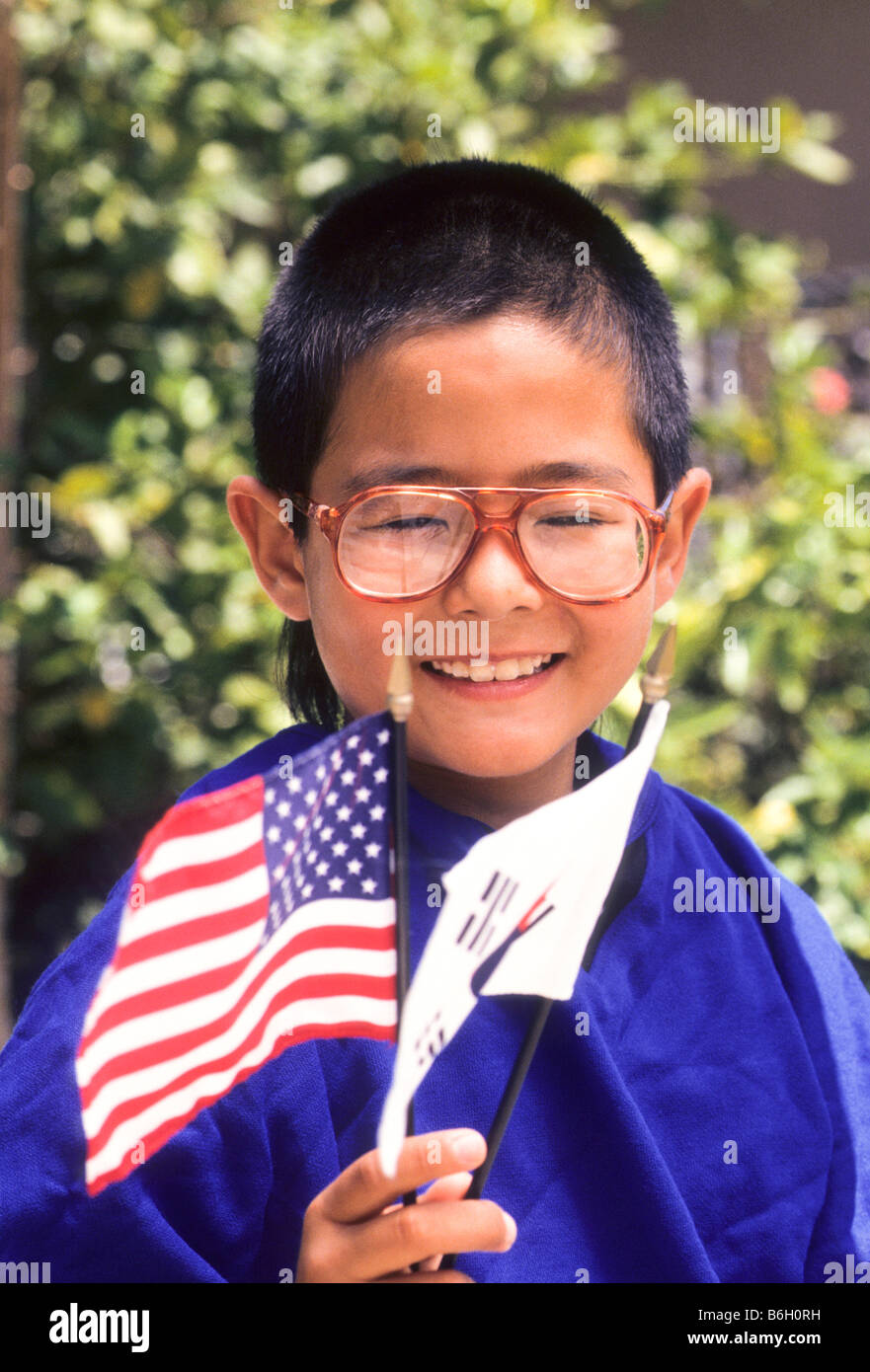Koreanisch-amerikanische Young Boy posiert mit amerikanischen und koreanischen Fahnen. Stockfoto